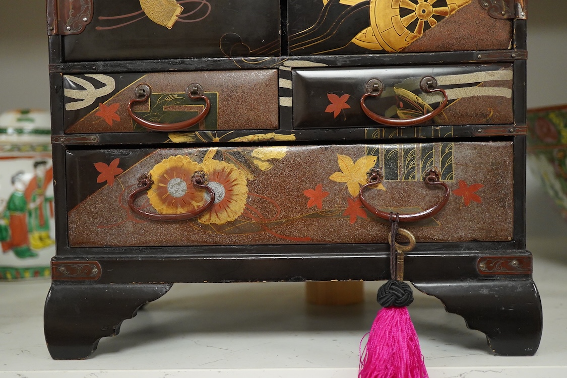 A Japanese gilt decorated black lacquer table cabinet, fitted with seven drawers, with key, 35cm high